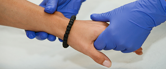Patientenhand wird gehalten von zwei "helfenden Händen".